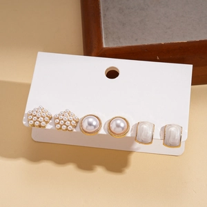 Detailed close-up of a 3-pair gold earring set featuring faux pearls and floral designs
