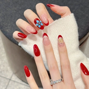 Faux ongles amande longs style french rouge avec motifs de fleurs en relief 3D