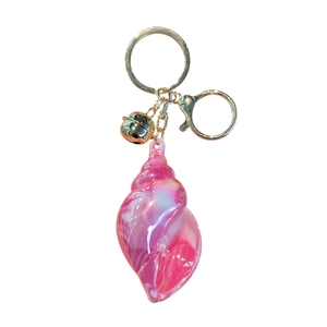Charming iridescent pink shell keychain with golden lobster clasp and small bell detail
