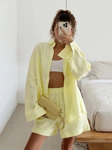 Mirror selfie of a woman wearing a casual light yellow linen long sleeve shirt and shorts set