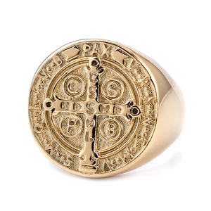 Detailed close-up of golden St. Benedict Medal ring featuring engraved religious symbols