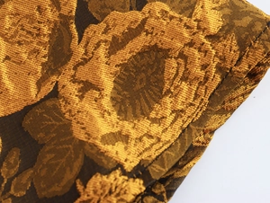 Macro-detail van elegante gouden jacquardstof met luxe hoogglanzende textuur