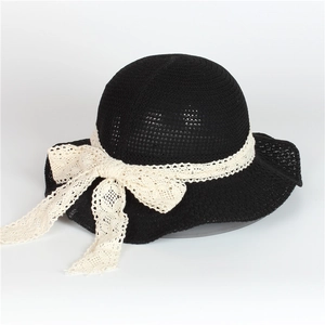 Détail d'un chapeau de paille noir avec ruban de dentelle crème élégant et joli nœud