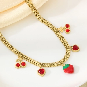 Detailaufnahme der Goldkette mit Anhängern aus roten Kristallen wie Kirsche und Herz