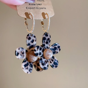 Detail of 18K gold-plated floral leopard print acetate earrings with sparkling micro-crystals