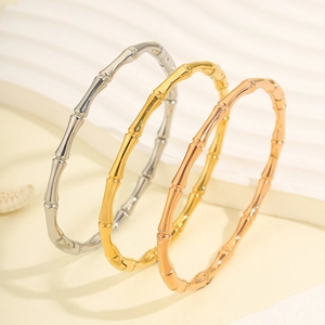 Bracciali in acciaio inossidabile stile bambù in oro, argento e oro rosa su sfondo ondulato