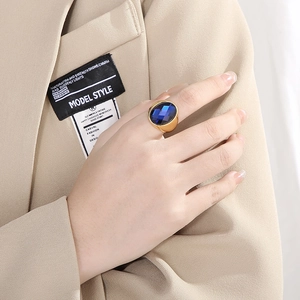 Detailed close-up of a gold-plated cocktail ring with a large oval blue gemstone