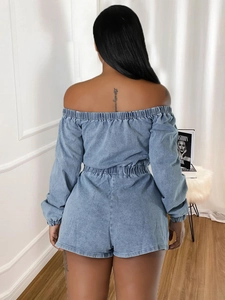 Denim off-shoulder romper with elastic waist and back pockets in a soft blue wash finish
