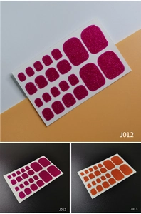 Detailed close-up of rose red and orange glitter toe nail stickers in various sizes