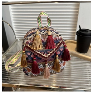 Detailed view of bohemian backpack with colorful woven patterns and vibrant fringe tassels