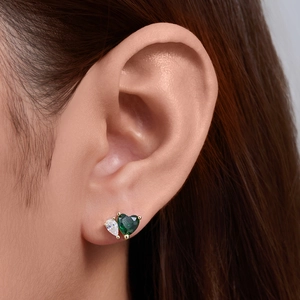 Elegant heart-shaped emerald zircon and pear-cut white stone stud earrings on ear