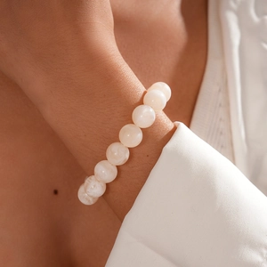Close-up of white geometric beads bracelet with cloud texture on a woman's wrist