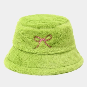 Détail de la texture en fausse fourrure pelucheuse et broderie nœud rose sur le chapeau vert