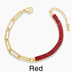 Detail of elegant gold chain bracelet with red rectangular zircon stones on white background