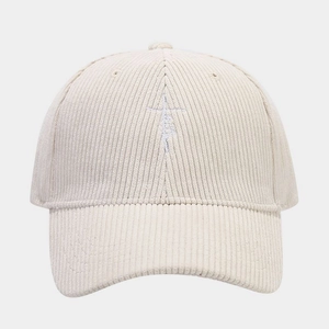 Detailed close-up of corduroy texture and cross embroidery on beige baseball cap
