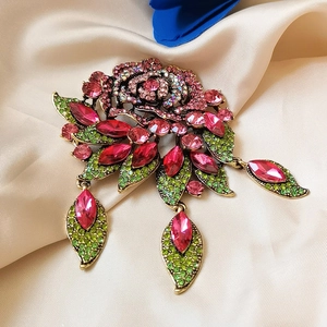 Macro detail of baroque rose brooch with pink rhinestones and antique gold finish