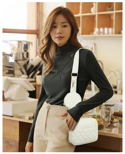 White quilted crossbody bag with adjustable wide strap and a small round coin purse charm