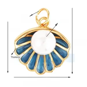Macro detail of enamel scallop pendant with a white pearl and gold ribbed texture