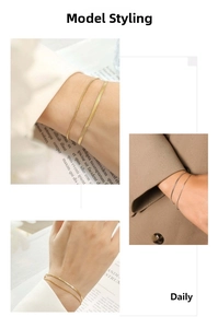 Close-up of elegant gold and silver double-layered snake bone chain bracelets on wrist