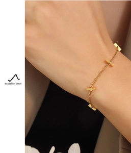 Detail of 18K gold plated stainless steel bamboo bar bracelet on a female wrist