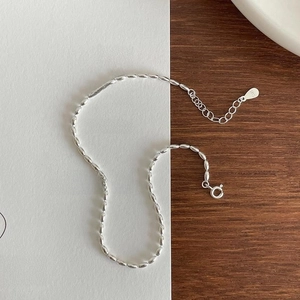 Macro detail of S925 sterling silver beaded anklet with lobster clasp and heart pendant