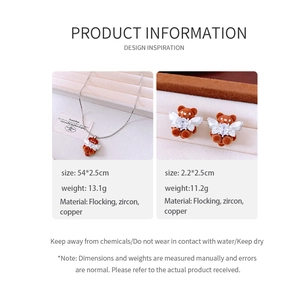Detail view of orange flocked bear jewelry set with zircon accents on beige suede