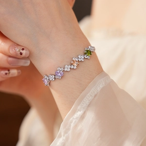 Detailed view of colorful geometric zircon bracelet on wrist with silver metal finish