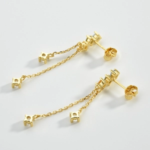 Close-up of elegant gold long tassel earrings with sparkling white cubic zirconia