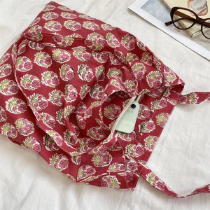 Detail of floral canvas tote bag featuring a hidden zipper pocket for smartphones