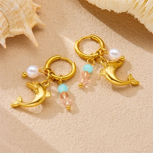 Gold dolphin earrings with sea-themed colorful beads and pearls on beach sand