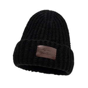 Winter black knit beanie with brown leather patch and thick warm ribbed texture