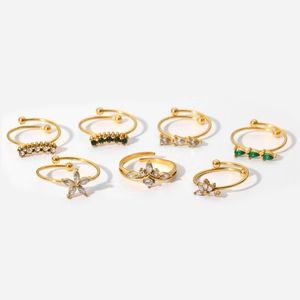 Set of seven gold plated adjustable rings with green crystals and floral zircon details