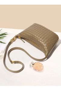 Dettaglio della borsa a spalla in pelle intrecciata kaki con cerniera dorata elegante