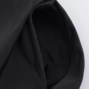 Close-up detail of the pocket and neat stitching on a black midi shirt dress