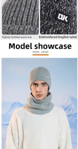 Close-up of gray knit beanie and neck warmer set with embroidery in a snowy scene