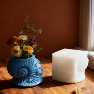 Deep blue conch shell resin mold and decorative vase with dried flowers on wood