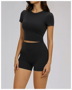 Detail of high-stretch black yoga set featuring cropped short sleeve top and cycling shorts