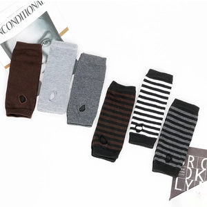 Close-up of assorted striped and solid knitted fingerless arm warmers with thumb holes