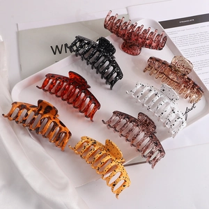 Flat lay view of eight large assorted hair claws in trendy tortoiseshell and glitter patterns