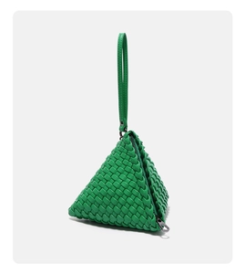 Macro view showing green hand-woven triangle bag with detailed leather texture and silver zipper