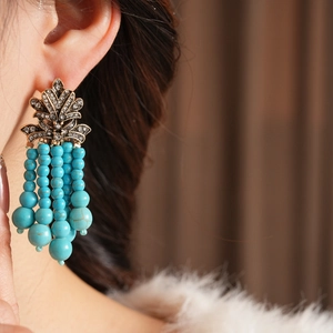 Detailansicht der Vintage-Ohrringe mit künstlichen Türkisperlen und glitzernden Quasten