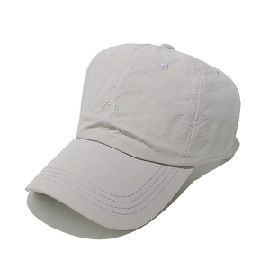 Close-up of the breathable nylon fabric and embroidered M logo on the lightweight baseball cap