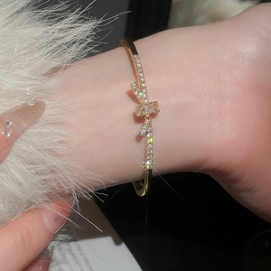 Détail d'un bracelet jonc doré orné d'un nœud étincelant serti de zircons brillants