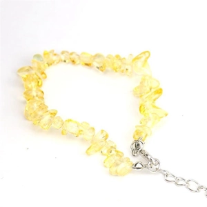 Detailed macro view of raw yellow crystal stones on an adjustable silver chain bracelet