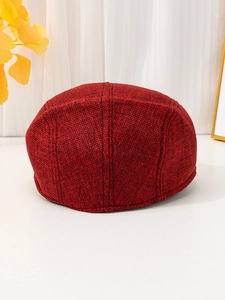 Detailed view of the dark red breathable linen newsboy cap with coarse woven texture