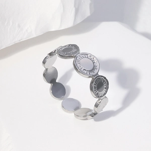 Minimalist silver stainless steel ring with sunburst pattern on geometric backdrop