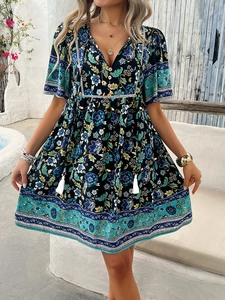 Detail of V-neck printed dress featuring floral patterns and white tassel pendants