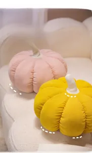 Texture détaillée des coussins citrouille en velours rose et jaune sur un canapé crème