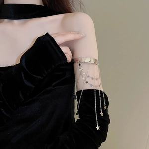 Detailed view of silver arm cuff with multi-layer tassel chains and star charms