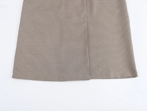 Dettaglio della trama del tessuto pied de poule marrone di un cappotto blazer doppiopetto
